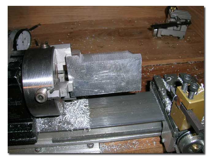 Piece in the 4-jaw chuck. The piece was mounted off center with the centerline of the of the future barel bore centered on the chuck. Because of this, the piece had to be turned at slow speed for the first steps of the work. Make sure the part is VERY well secured in the chuck. I used the slowest speed possible on my lathe for this step and it worked very well, it just took more time. Piece in the 4-jaw chuck. The piece was mounted off center with the centerline of the of the future barel bore centered on the chuck. Because of this, the piece had to be turned at slow speed for the first steps of the work. Make sure the part is VERY well secured in the chuck. I used the slowest speed possible on my lathe for this step and it worked very well, it just took more time.